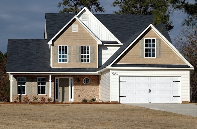 beige house with a driveway and garage